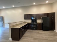 Shows an angle view of a series of single story brick row house entrances